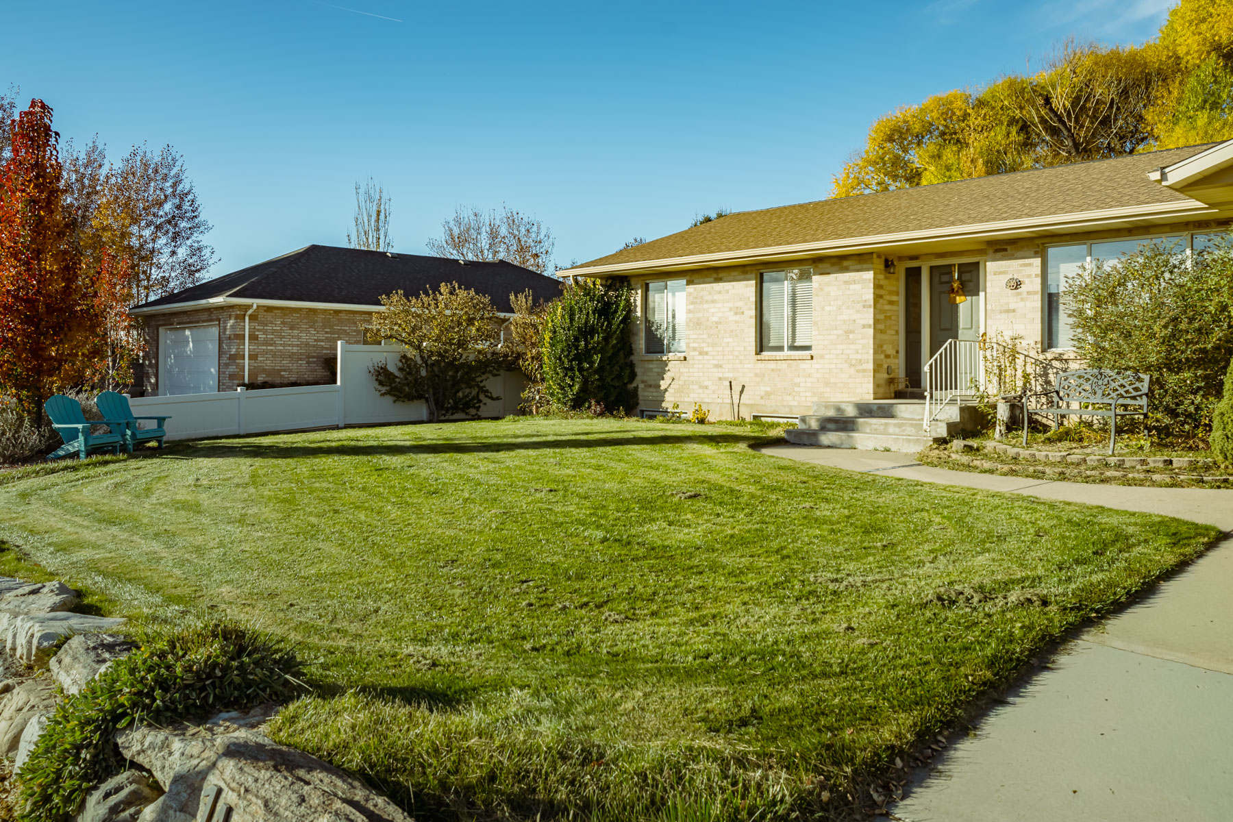 Residential front lawn and brick home in Davis County Utah, showing green turf maintained with lawn care and lawn treatment.